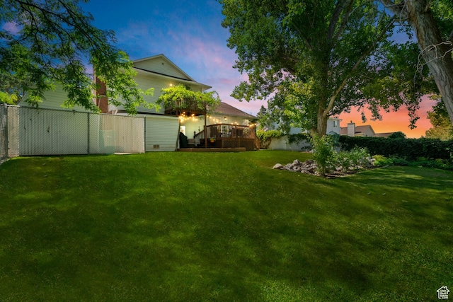 yard at dusk with fence and a deck