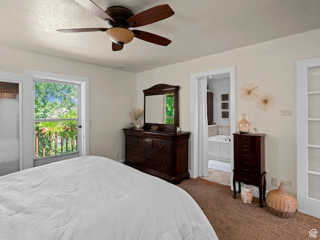 carpeted bedroom with ensuite bath, a textured ceiling, and ceiling fan