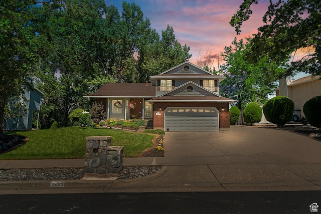 view of front of home with brick siding, an attached garage, driveway, and a front yard