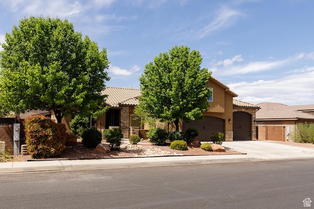 2562 S 4010 W, Hurricane, UT 84737 - view of front of home with concrete driveway, stucco siding, a tile roof, stone siding, and a garage