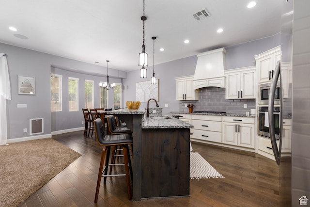 2562 S 4010 W, Hurricane, UT 84737 - kitchen featuring visible vents, a sink, premium range hood, appliances with stainless steel finishes, and a breakfast bar area