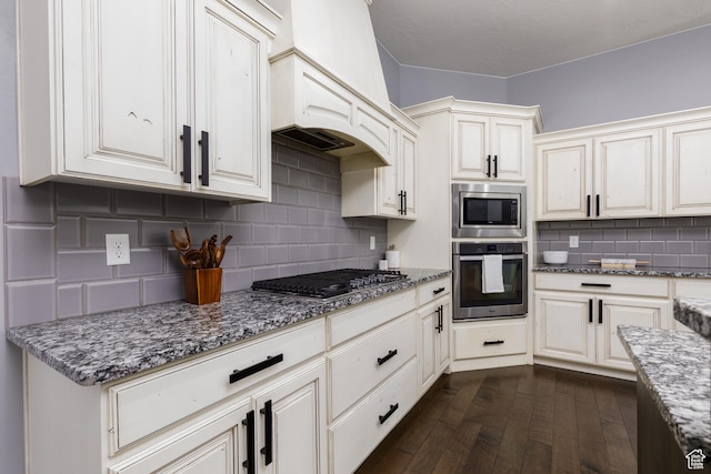 2562 S 4010 W, Hurricane, UT 84737 - kitchen with dark wood-style floors, custom exhaust hood, backsplash, light stone countertops, and appliances with stainless steel finishes