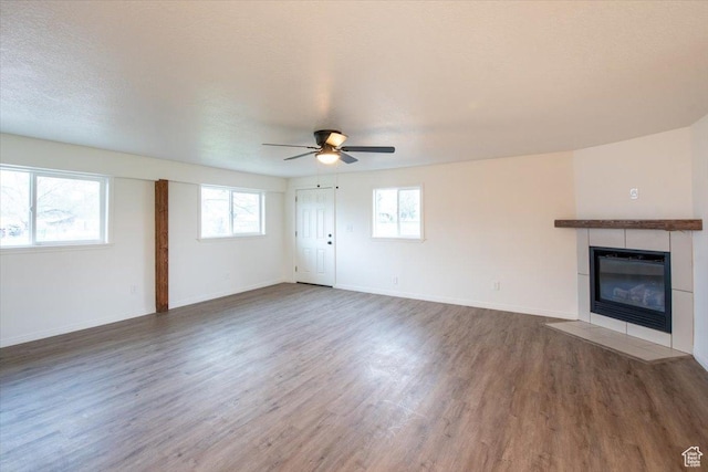 2389 S 4300 W, Taylor, UT 84401 - unfurnished living room featuring baseboards, ceiling fan, a fireplace, and wood finished floors