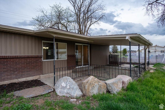 2389 S 4300 W, Taylor, UT 84401 - view of exterior entry with board and batten siding, brick siding, and fence