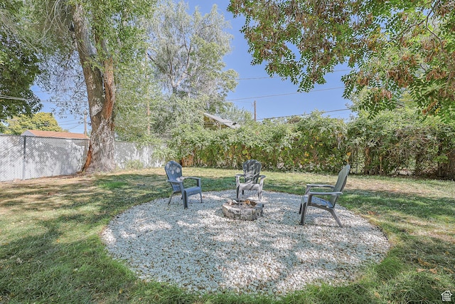 view of yard with an outdoor fire pit and fence