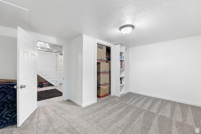 unfurnished bedroom with baseboards, carpet floors, a textured ceiling, and a closet