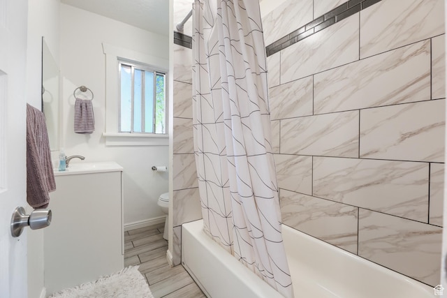 full bath featuring wood finished floors, vanity, baseboards, toilet, and shower / bath combo with shower curtain