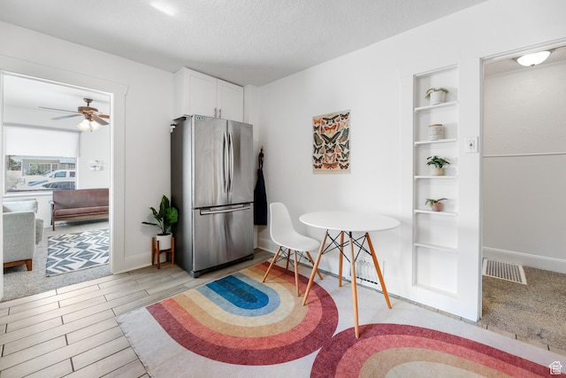 dining space with baseboards, visible vents, built in features, and ceiling fan