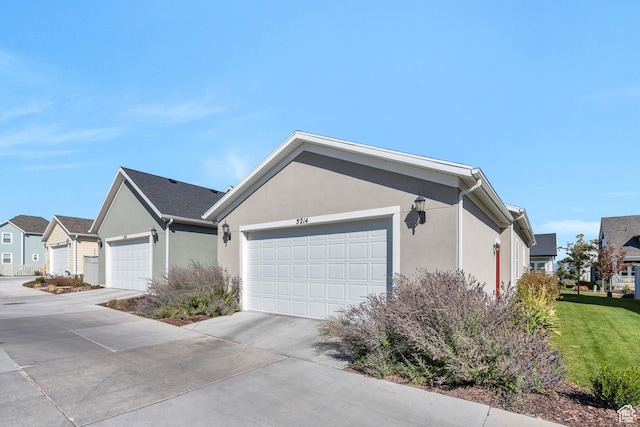 view of side of property with stucco siding, driveway, and a garage