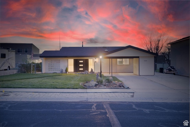 view of front facade featuring a carport, a front yard, and concrete driveway