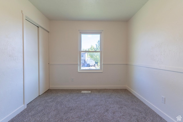 unfurnished bedroom with baseboards, visible vents, carpet floors, and a closet