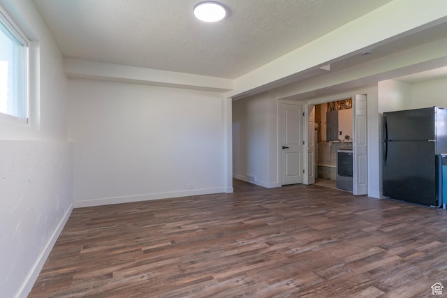 spare room with washer / clothes dryer, dark wood-style floors, and baseboards