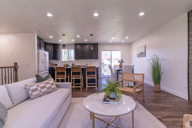 living area with baseboards, recessed lighting, and wood finished floors