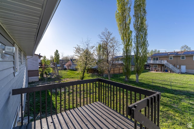 wooden deck featuring a residential view, a yard, and fence
