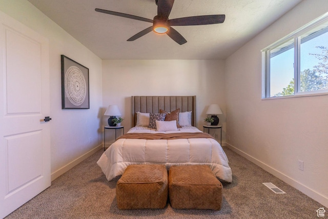 carpeted bedroom featuring visible vents, ceiling fan, and baseboards