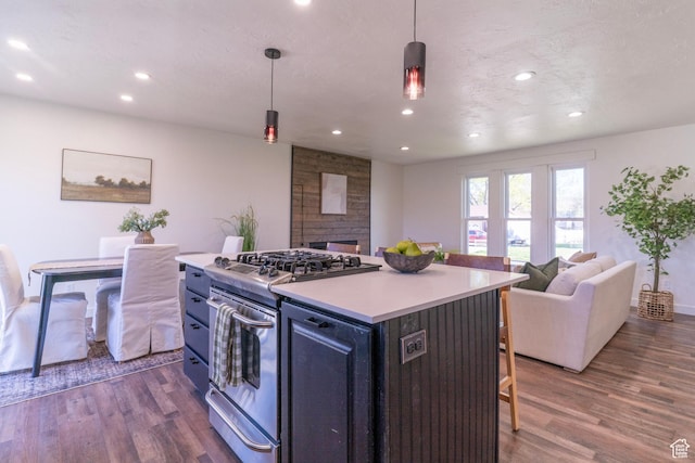kitchen featuring a breakfast bar area, open floor plan, stainless steel gas range oven, and dark wood-style floors