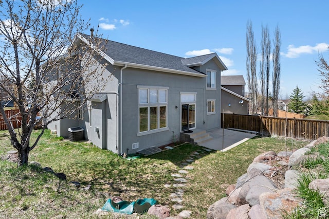 back of property featuring fence, a shingled roof, a yard, cooling unit, and a patio