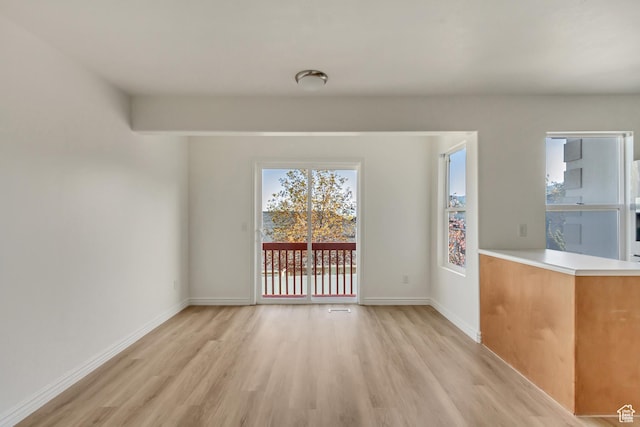 unfurnished dining area featuring light wood-style floors and baseboards