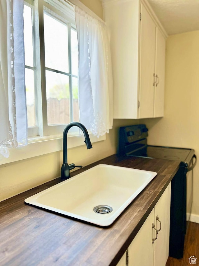 152 N 400 E, Vernal, UT 84078 - kitchen featuring dark countertops, a sink, electric range oven, white cabinets, and dark wood-type flooring