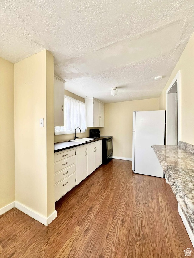 152 N 400 E, Vernal, UT 84078 - kitchen with wood finished floors, freestanding refrigerator, a textured ceiling, and electric range