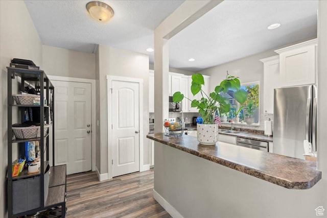 1521 W Kinloch Way, West Valley City, UT 84119 - kitchen featuring white cabinets, dark countertops, appliances with stainless steel finishes, and dark wood finished floors