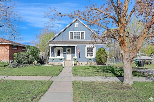 453 N 200 W, Brigham City, UT 84302 - bungalow with board and batten siding, a front lawn, and fence