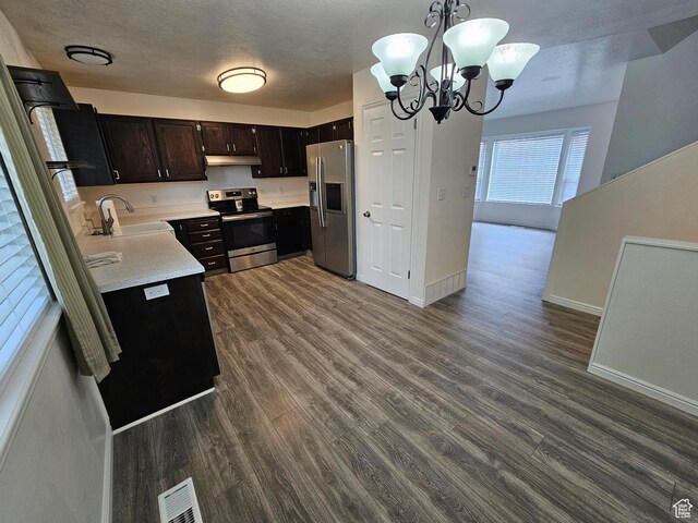 723 E 200 N, Orem, UT 84097 - kitchen with appliances with stainless steel finishes, a sink, light countertops, an inviting chandelier, and under cabinet range hood