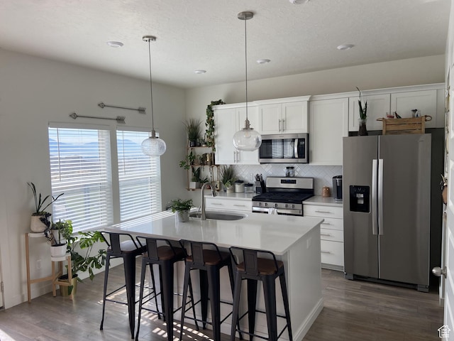 9372 N Scenic Mountain Dr W, Eagle Mountain, UT 84005 - kitchen featuring an island with sink, a kitchen breakfast bar, stainless steel appliances, backsplash, and a sink