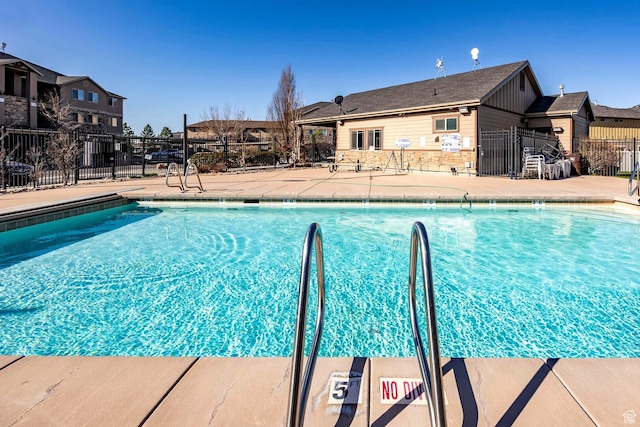 community pool featuring fence and a patio area
