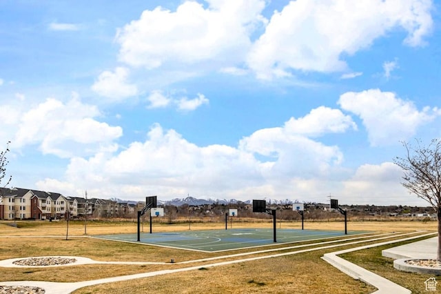 view of basketball court with community basketball court and a lawn
