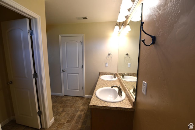 bathroom featuring visible vents, baseboards, and a sink