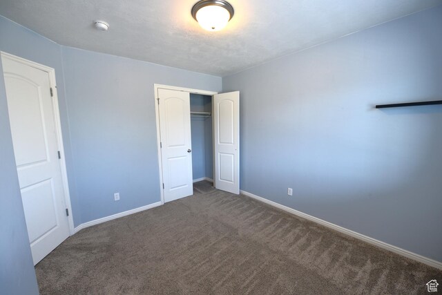 unfurnished bedroom featuring carpet floors, a closet, and baseboards
