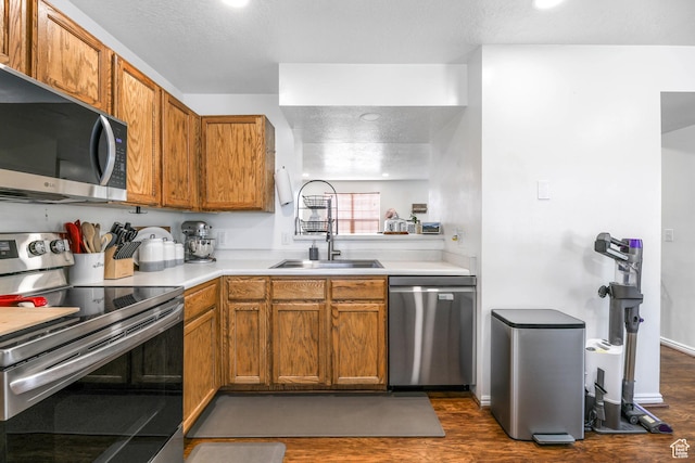 734 N 170 W, Tooele, UT 84074 - kitchen with stainless steel appliances, a sink, dark wood-style flooring, brown cabinetry, and light countertops