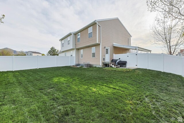 734 N 170 W, Tooele, UT 84074 - back of house featuring a fenced backyard, entry steps, and a lawn