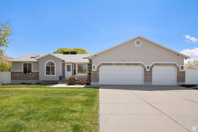 ranch-style house with stucco siding, driveway, brick siding, a front yard, and a garage