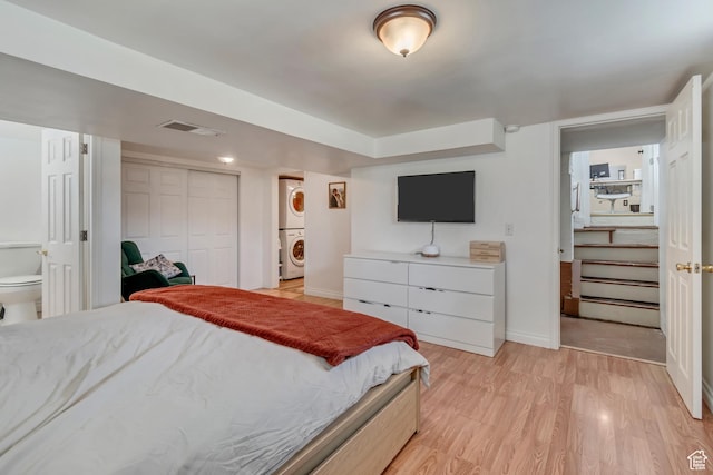 647 E 3065 S, South Salt Lake, UT 84106 - bedroom featuring light wood-type flooring, stacked washer and dryer, baseboards, and visible vents