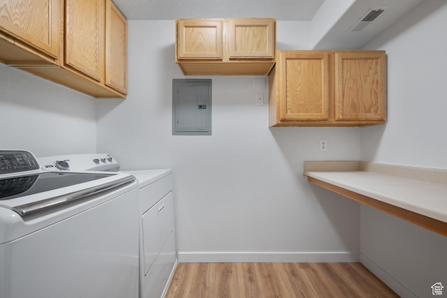 washroom featuring washing machine and dryer, cabinet space, visible vents, and electric panel