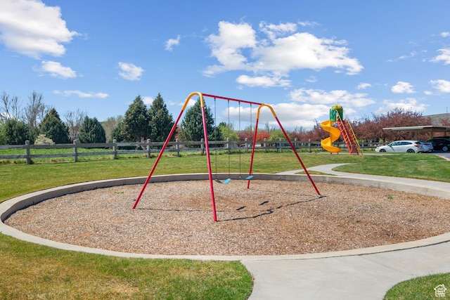 communal playground featuring fence and a yard