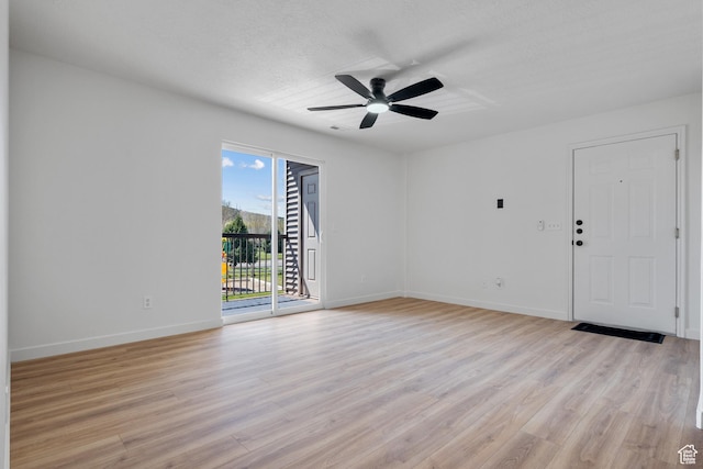 empty room featuring light wood-style flooring, baseboards, and ceiling fan