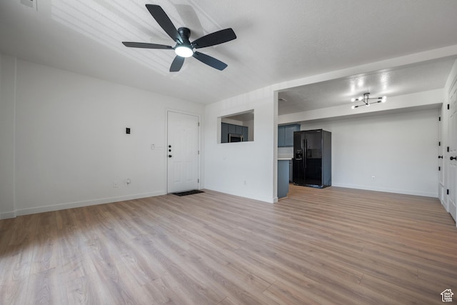 unfurnished living room featuring light wood-style flooring, a ceiling fan, and baseboards