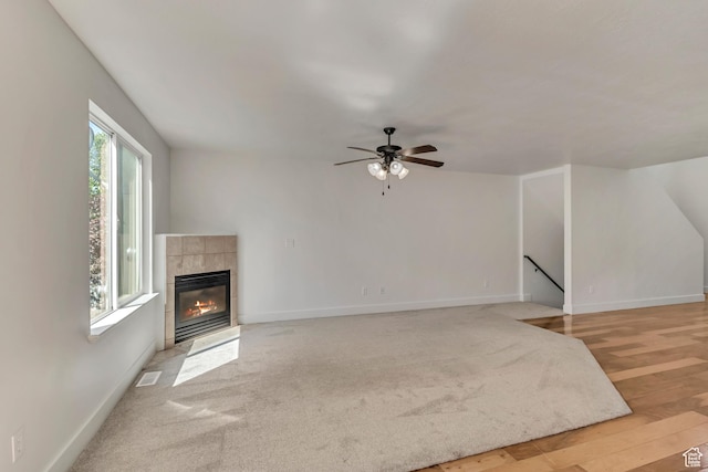 2074 S Orchard Dr, Bountiful, UT 84010 - unfurnished living room featuring ceiling fan, a tiled fireplace, light colored carpet, baseboards, and visible vents