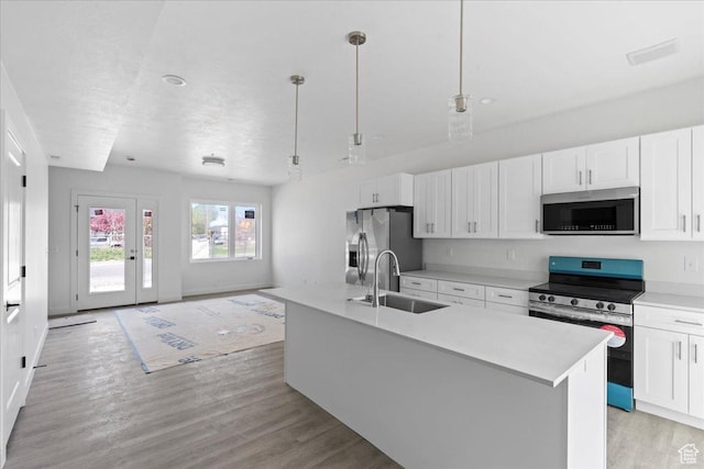 805 S 800 W Unit D, Salt Lake City, UT 84104 - kitchen with white cabinets, stainless steel appliances, light wood-style flooring, a sink, and light countertops