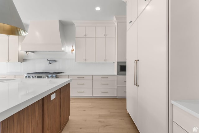 3382 E Ezra Ln, St George, UT 84790 - kitchen featuring recessed lighting, light countertops, light wood-type flooring, white cabinetry, and custom range hood