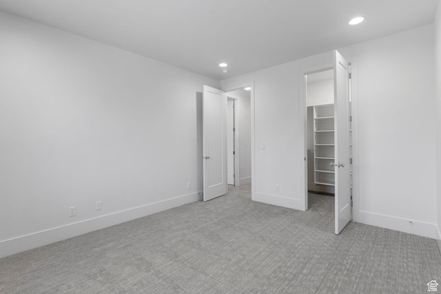 3382 E Ezra Ln, St George, UT 84790 - unfurnished bedroom with light colored carpet, baseboards, a walk in closet, and recessed lighting