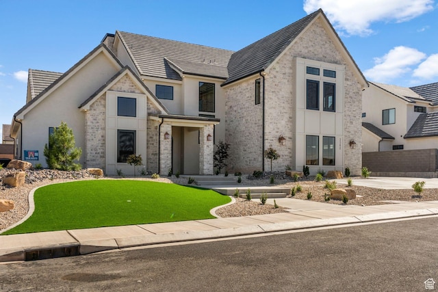 3382 E Ezra Ln, St George, UT 84790 - view of front facade featuring stone siding, a front lawn, fence, and stucco siding