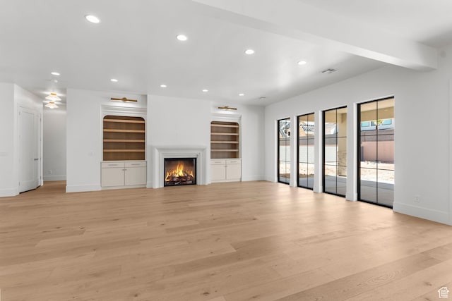 3382 E Ezra Ln, St George, UT 84790 - unfurnished living room featuring visible vents, baseboards, recessed lighting, light wood-style floors, and a warm lit fireplace