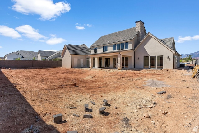 3382 E Ezra Ln, St George, UT 84790 - back of house featuring stucco siding, fence, and a chimney