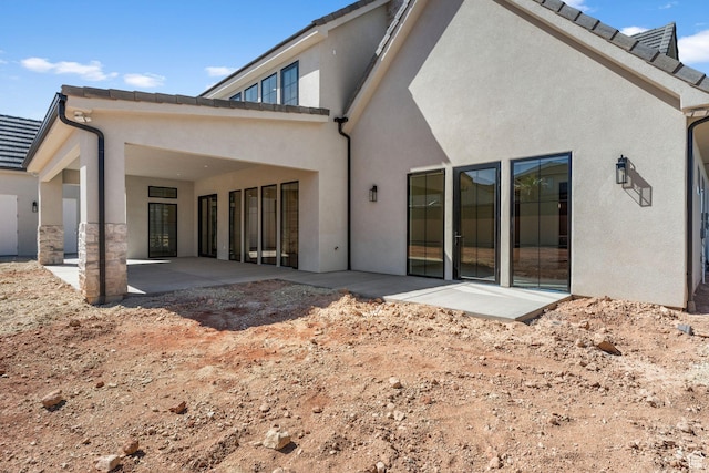 3382 E Ezra Ln, St George, UT 84790 - rear view of house featuring stucco siding and a patio area