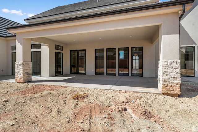 3382 E Ezra Ln, St George, UT 84790 - rear view of house with a patio area, stone siding, and stucco siding