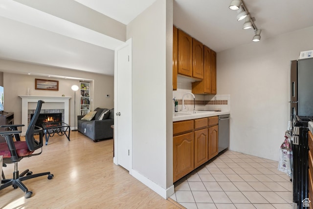 5552 S Willow Ln E Unit C, Salt Lake City, UT 84107 - kitchen with light wood-style flooring, light countertops, a sink, dishwasher, and a fireplace